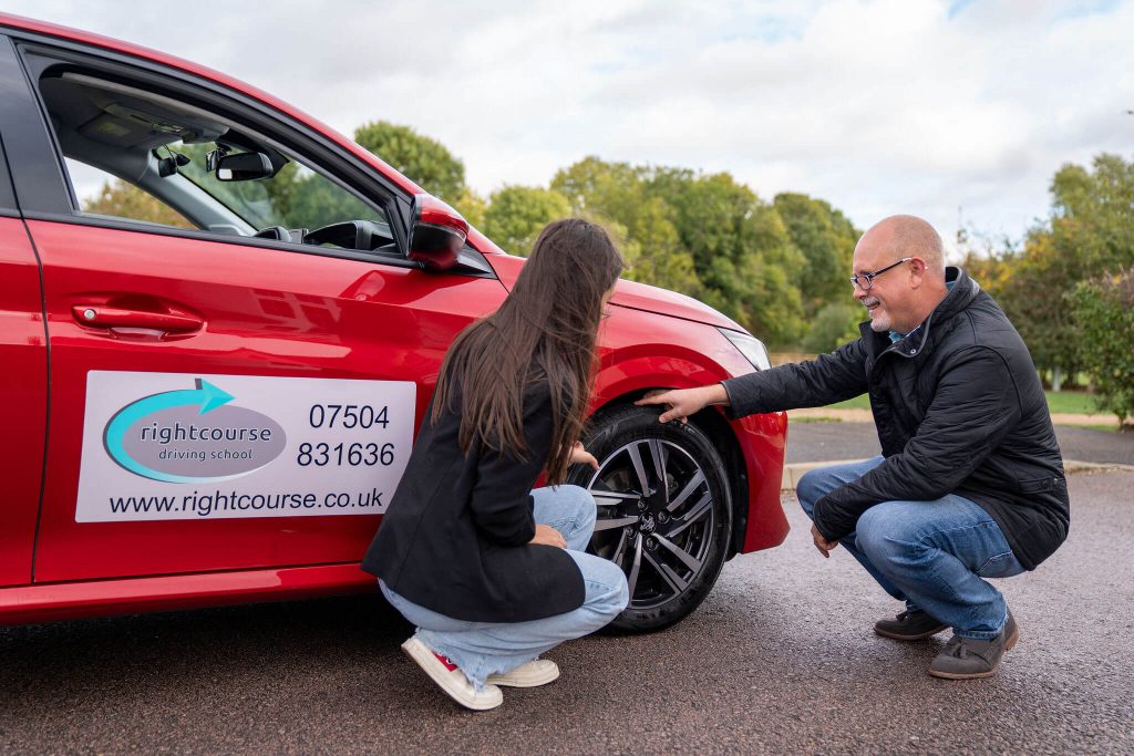 Jason Fleming showing a pupil what to look for on a cars tyres