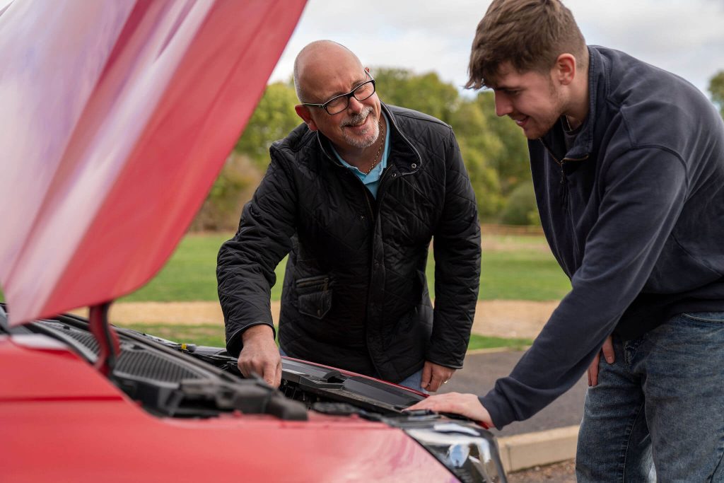 Jason Fleming showing a pupil the cars engine