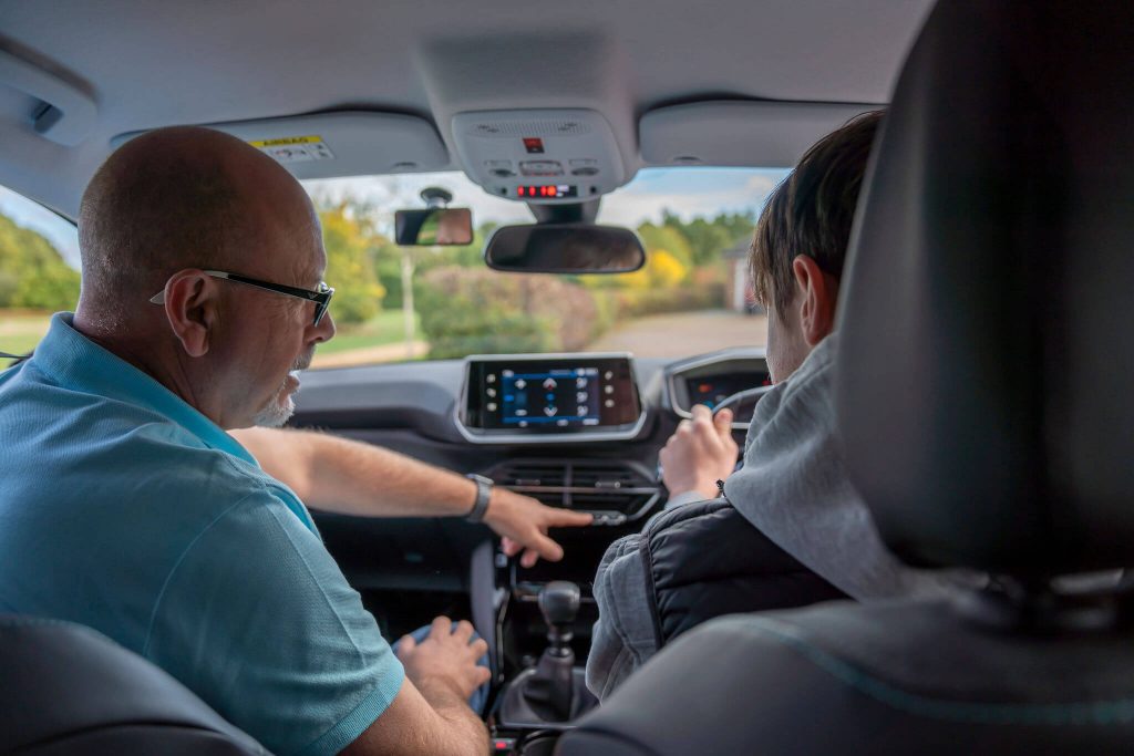 Jason Fleming with a pupil in his car showing them the controls